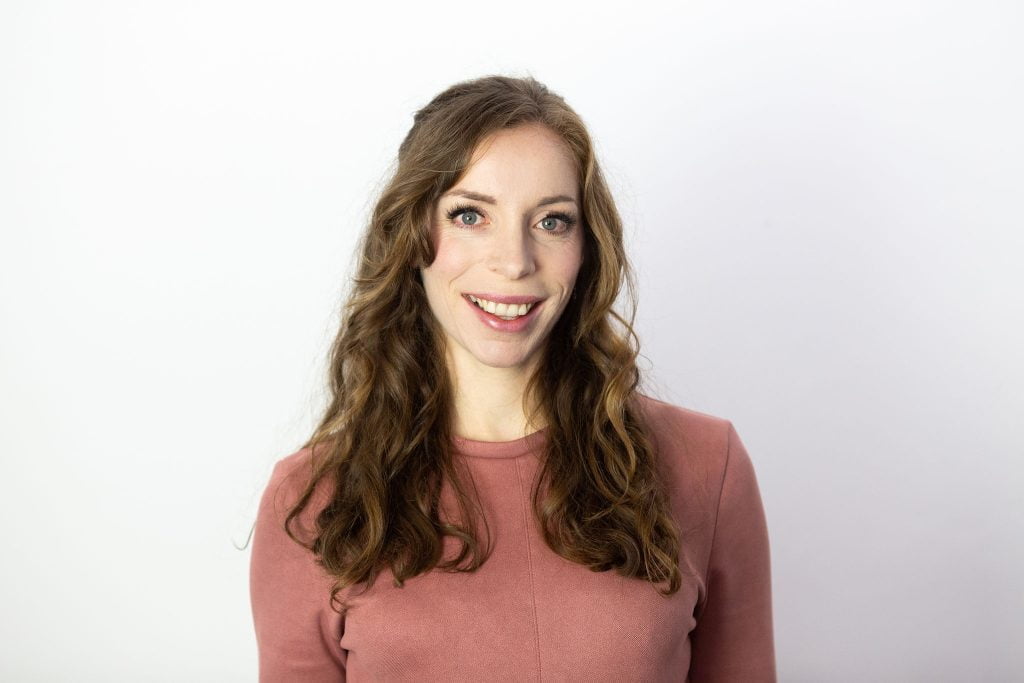 Image of Rose smiling in front of a white wall
